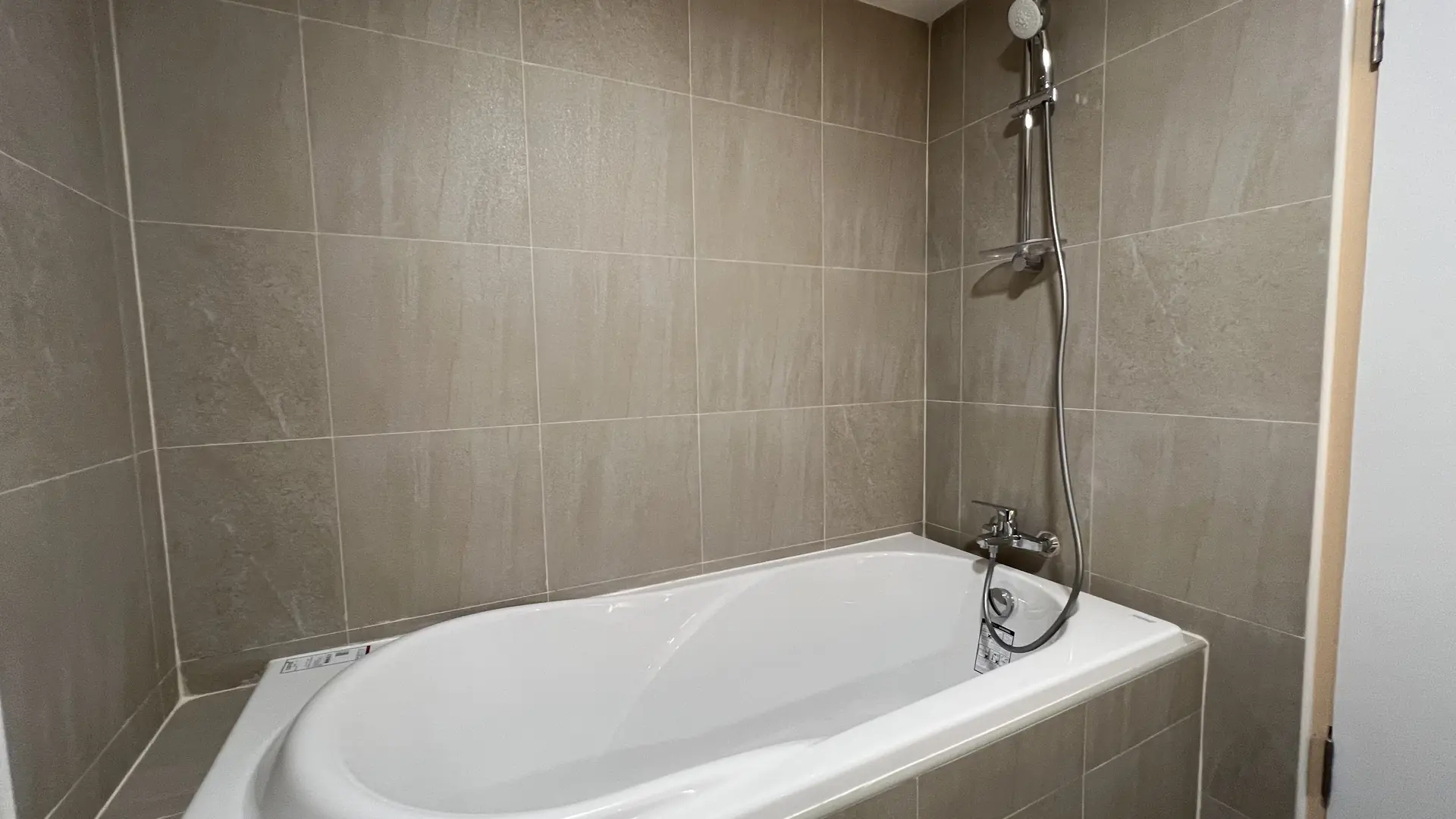 Soaking tub with stone-look tile and hand shower
